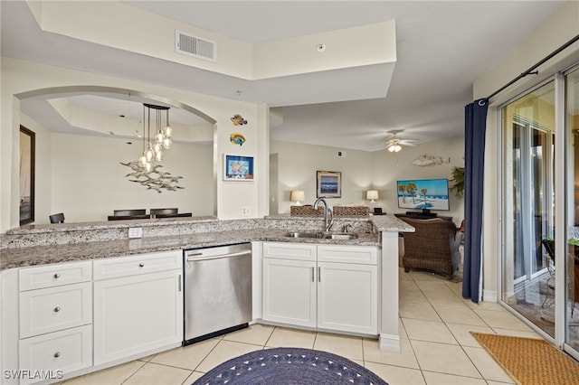 kitchen featuring a sink, visible vents, open floor plan, stainless steel dishwasher, and light stone countertops