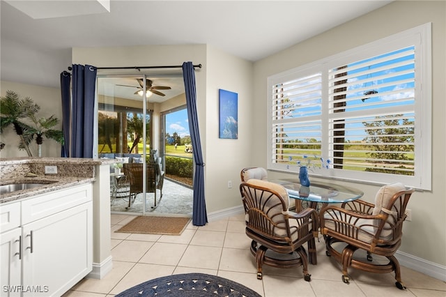 tiled dining space featuring ceiling fan, sink, and a healthy amount of sunlight