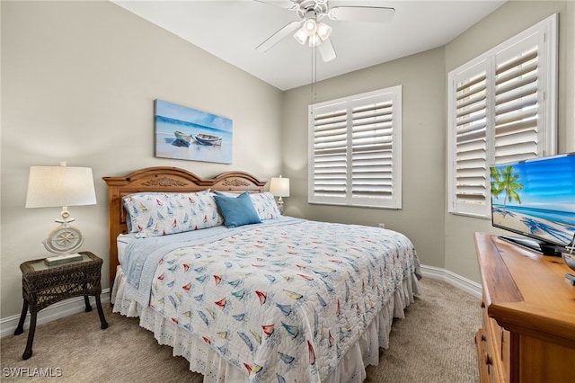 carpeted bedroom with ceiling fan and baseboards