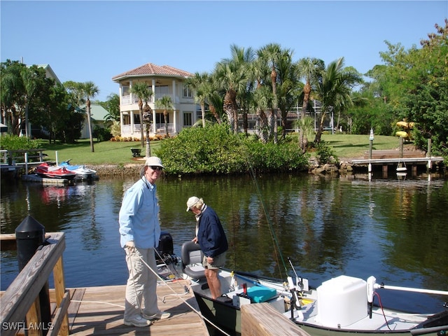 dock area with a yard and a water view