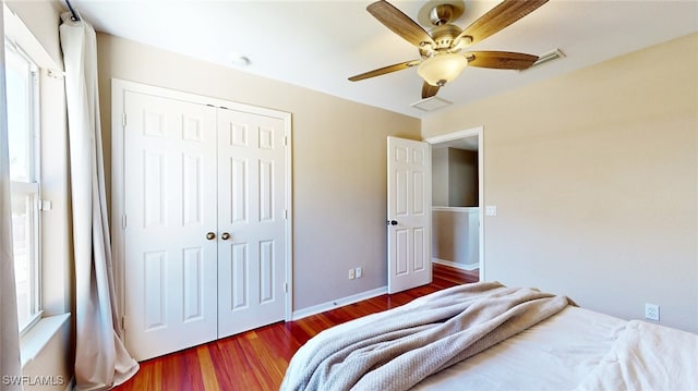 bedroom with multiple windows, hardwood / wood-style floors, a closet, and ceiling fan