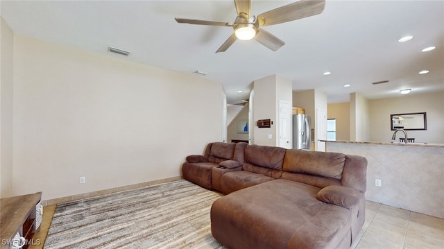 living room with ceiling fan, sink, and light tile patterned floors