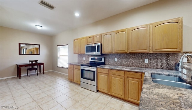 kitchen featuring light tile patterned flooring, sink, appliances with stainless steel finishes, and tasteful backsplash