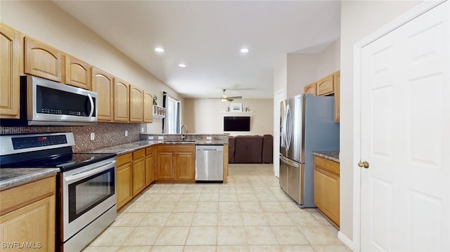 kitchen featuring backsplash, dark stone counters, sink, ceiling fan, and stainless steel appliances