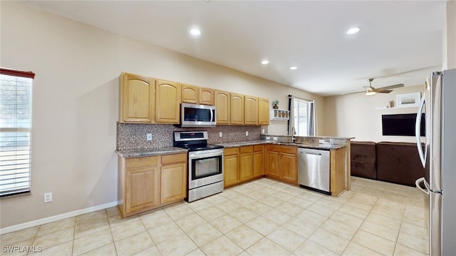 kitchen featuring ceiling fan, stainless steel appliances, light stone counters, kitchen peninsula, and decorative backsplash