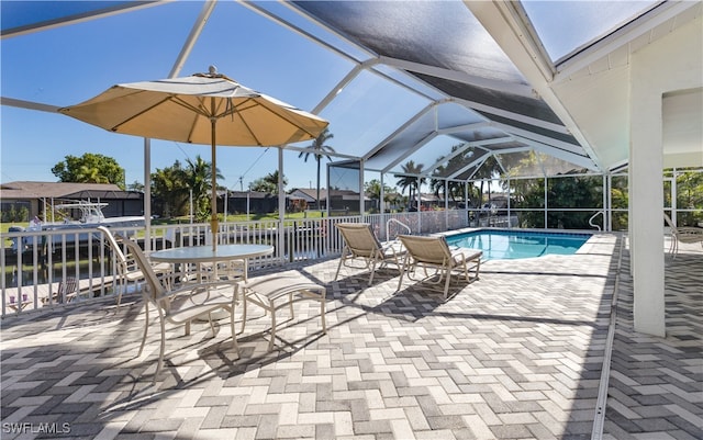 view of swimming pool featuring a patio and glass enclosure