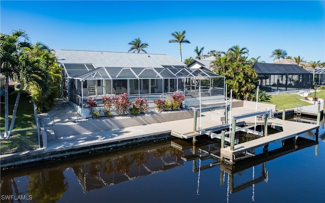 back of house with a water view and glass enclosure