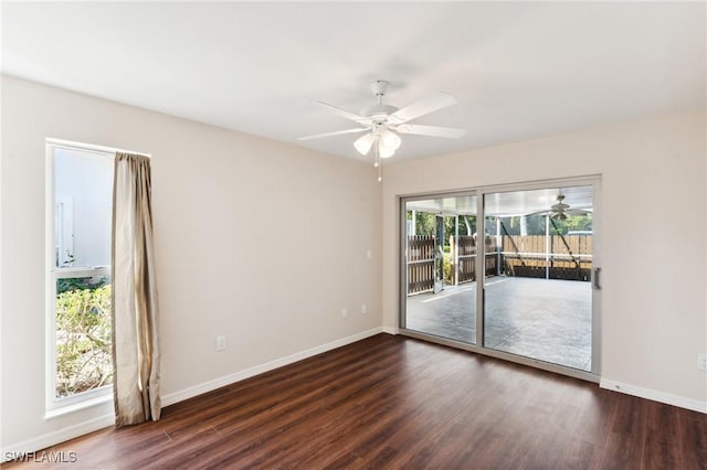 unfurnished room with dark wood-style floors, a ceiling fan, and baseboards