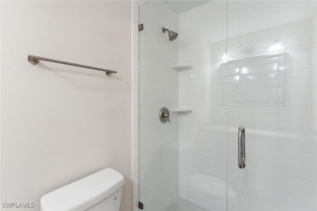 full bathroom with a shower stall and toilet