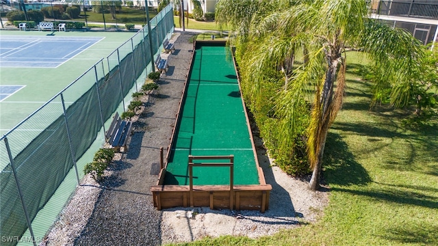 surrounding community with a tennis court, a lawn, and fence