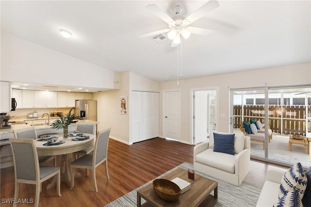 living room featuring lofted ceiling, ceiling fan, dark wood-type flooring, visible vents, and baseboards