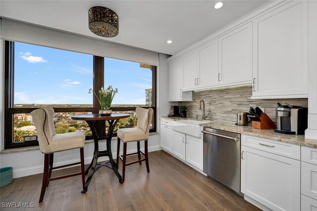 kitchen with white cabinets, dishwasher, light stone countertops, and sink