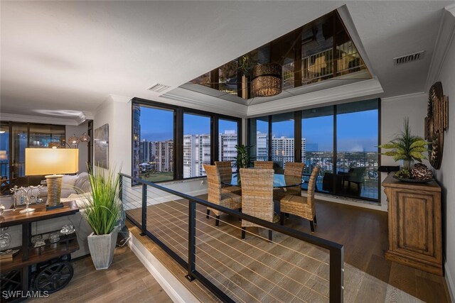 dining room with floor to ceiling windows, ornamental molding, and hardwood / wood-style flooring