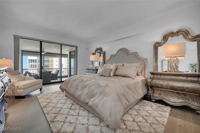 bedroom featuring expansive windows, access to exterior, and wood-type flooring