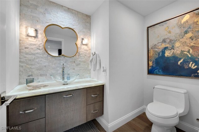 bathroom with hardwood / wood-style floors, vanity, and toilet