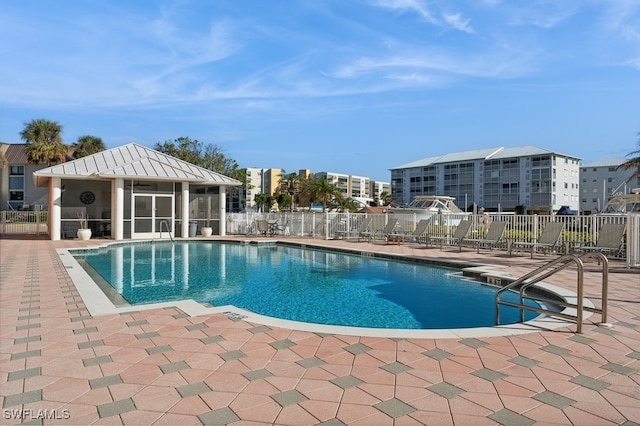 view of pool with a sunroom and a patio