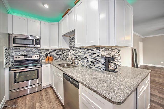 kitchen featuring white cabinetry, sink, stainless steel appliances, dark hardwood / wood-style floors, and ornamental molding