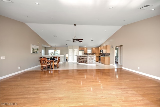 unfurnished living room with ceiling fan, light hardwood / wood-style floors, and high vaulted ceiling