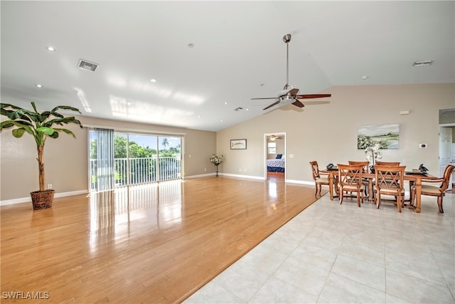 living room with ceiling fan, light wood-type flooring, and vaulted ceiling