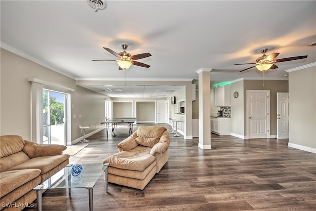 living room with dark hardwood / wood-style floors, ceiling fan, and ornamental molding