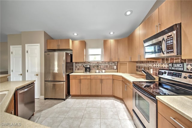 kitchen featuring decorative backsplash, light brown cabinetry, light tile patterned floors, and appliances with stainless steel finishes