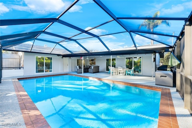 view of swimming pool with glass enclosure and a patio area