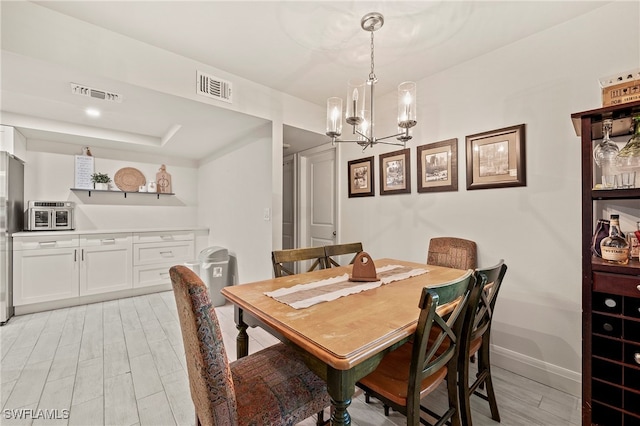 dining space featuring a notable chandelier and light hardwood / wood-style floors