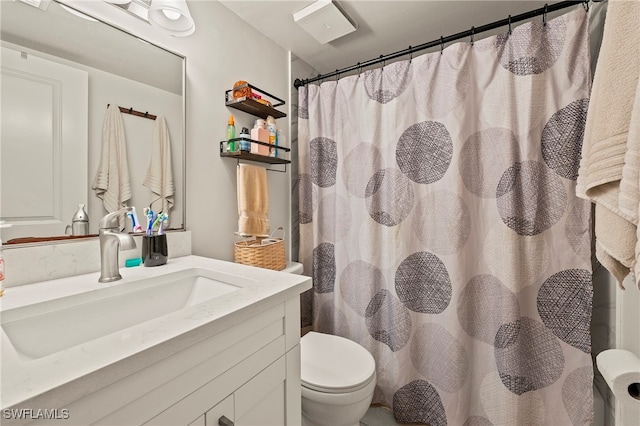 bathroom featuring vanity, toilet, and walk in shower