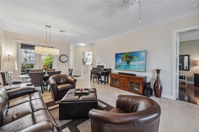 living area with ceiling fan, light tile patterned floors, and ornamental molding