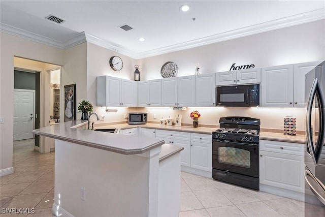 kitchen with a sink, visible vents, black appliances, and a peninsula