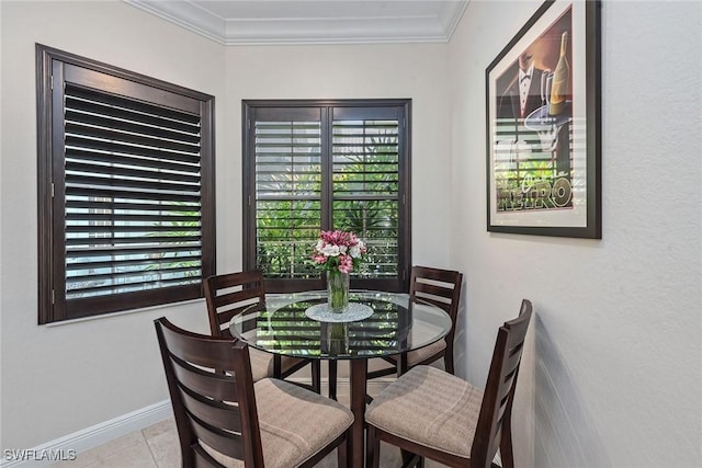 tiled dining space featuring baseboards and ornamental molding