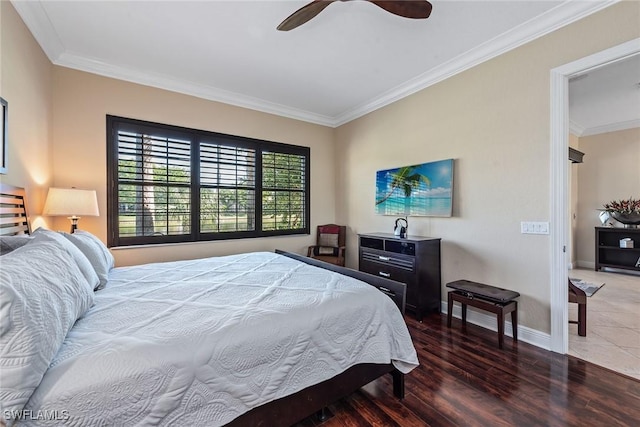 bedroom featuring a ceiling fan, wood finished floors, baseboards, and ornamental molding