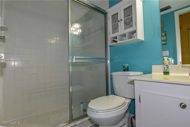 bathroom with vanity, a shower with shower door, and toilet