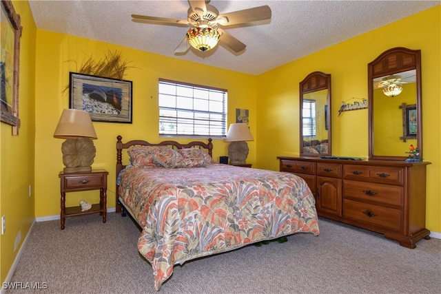 carpeted bedroom featuring ceiling fan and a textured ceiling