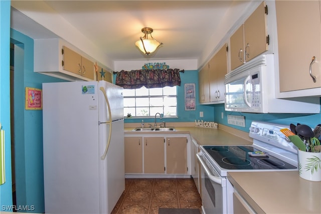 kitchen featuring cream cabinetry, white appliances, and sink