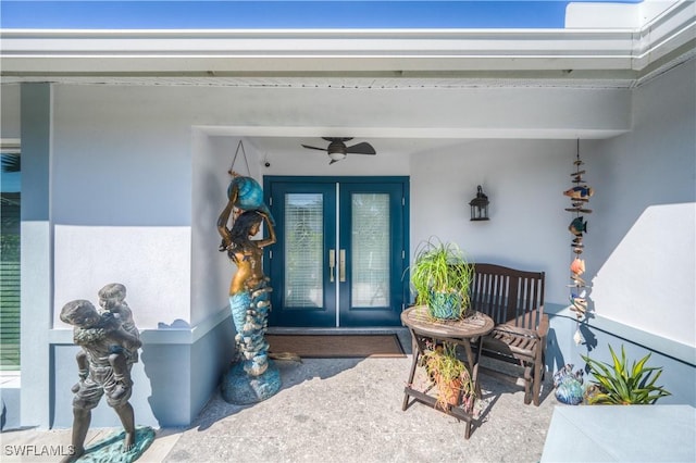 property entrance with stucco siding, ceiling fan, and french doors