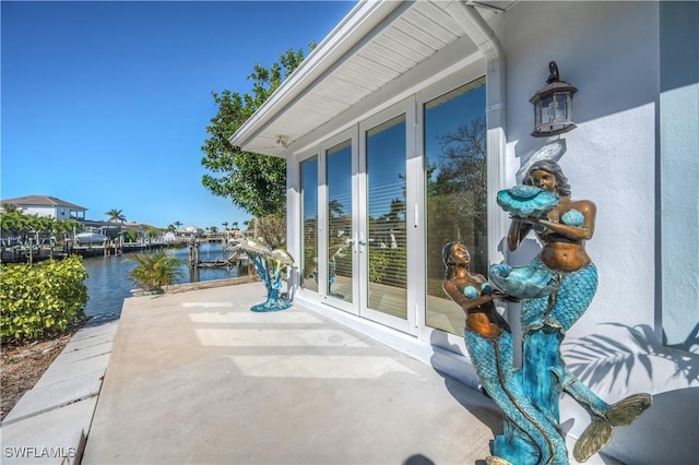 view of patio / terrace with french doors and a water view