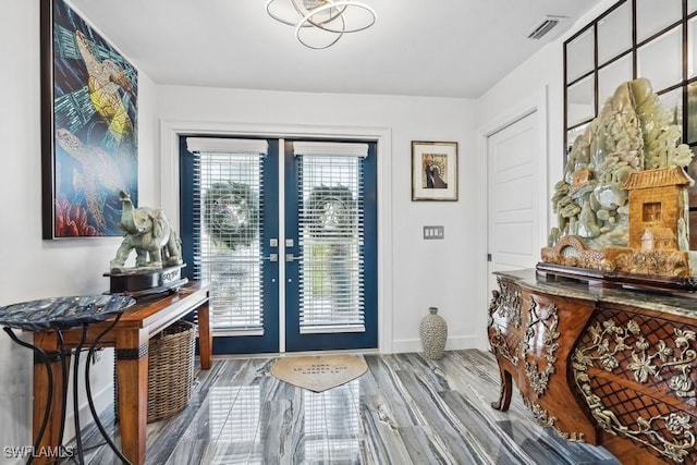 foyer entrance featuring french doors, wood finished floors, visible vents, and baseboards