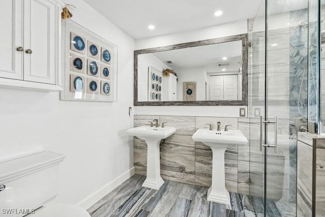 full bathroom with a stall shower, baseboards, toilet, wood finished floors, and recessed lighting