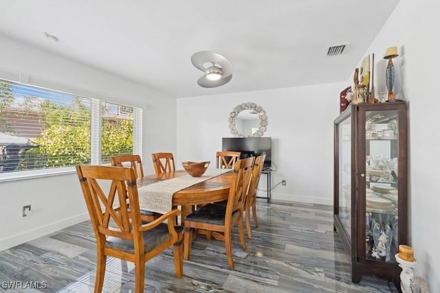 dining room with baseboards, visible vents, and wood finished floors