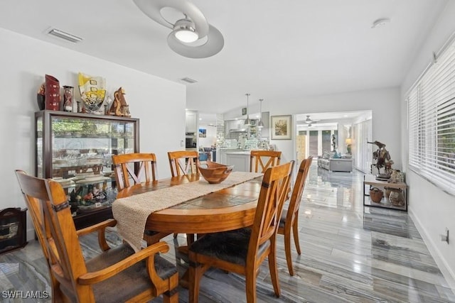 dining area featuring visible vents, ceiling fan, and baseboards