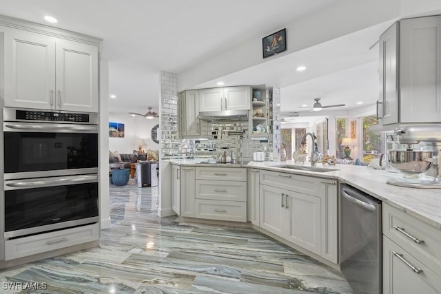 kitchen featuring stainless steel appliances, recessed lighting, decorative backsplash, a sink, and ceiling fan