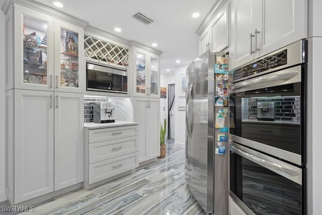 kitchen with appliances with stainless steel finishes, recessed lighting, white cabinets, and visible vents