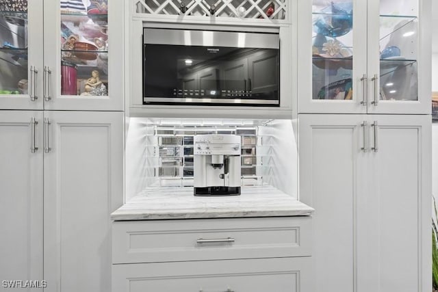 details featuring stainless steel microwave and backsplash