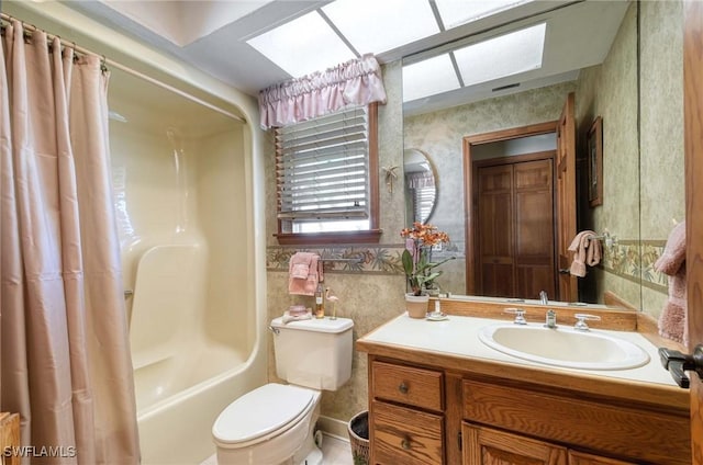 full bathroom featuring toilet, vanity, a skylight, and shower / tub combo with curtain