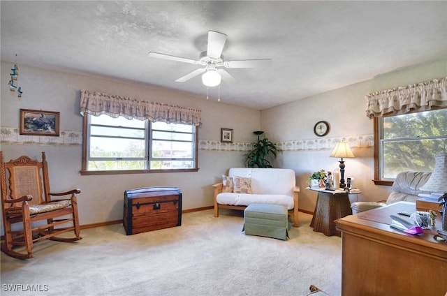 living area with ceiling fan and carpet