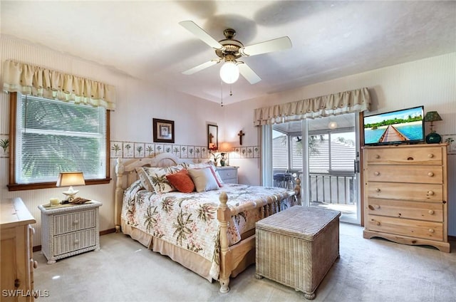 carpeted bedroom with access to exterior, ceiling fan, and multiple windows