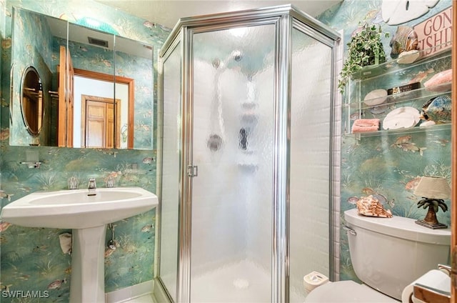 bathroom with toilet and a shower with shower door