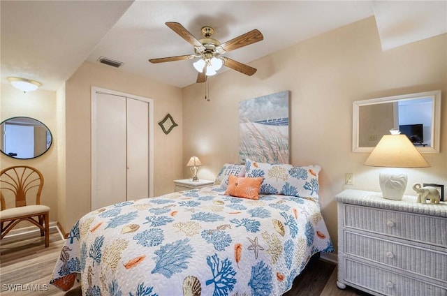 bedroom with hardwood / wood-style flooring, ceiling fan, and a closet