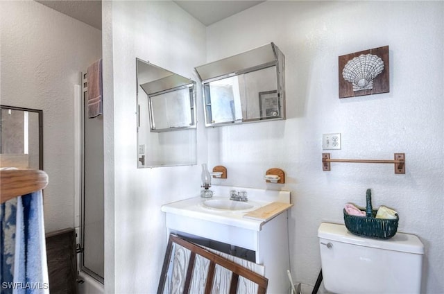 bathroom with walk in shower, vanity, and toilet